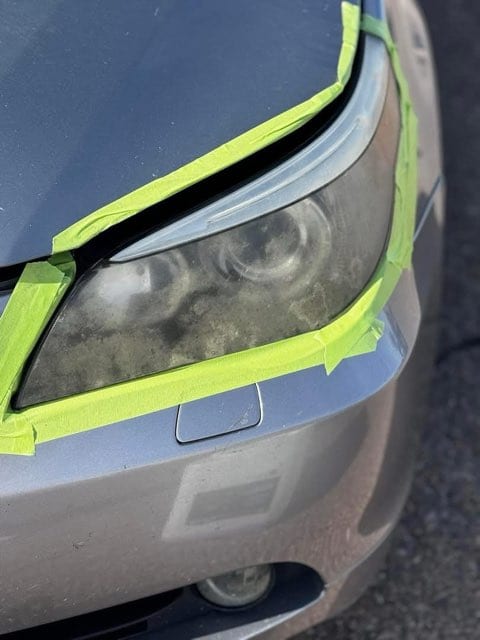 Foggy oxidized headlight taped off before restoration