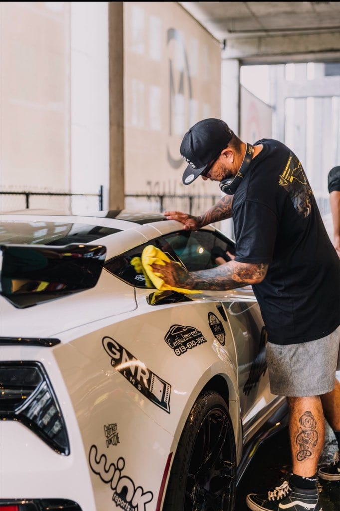 Nico buffing a white Corsa America rally car
