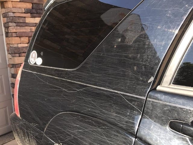 Heavily scratched and dull black paint before correction